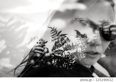 Portrait of beautiful young woman black and white double exposure photo, fern leaves overlay. Girl in sunglasses on vacation in summer Attractive girl Portrait of beautiful young woman black and white double exposure photo, fern leaves overlay. Girl in sunglasses on vacation in summer Attractive girl 125290012