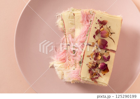 Trendy pink chocolate with airy filling on marble board. Tasty dessert. 125290199