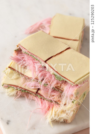 Trendy pink chocolate with airy filling on marble board. 125290203