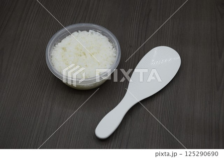 しゃもじと保存容器に入った白米 125290690