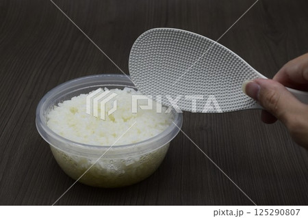 しゃもじと保存容器に入った白米 125290807
