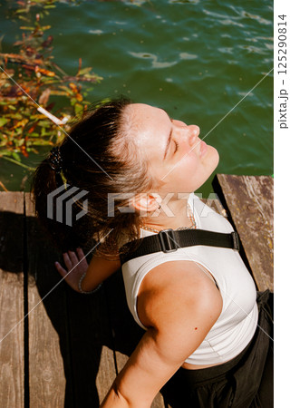 Relaxing moment by the water on a sunny day. Weekend concept near the forest and lake Relaxing moment by the water on a sunny day. Weekend concept near the forest and lake 125290814