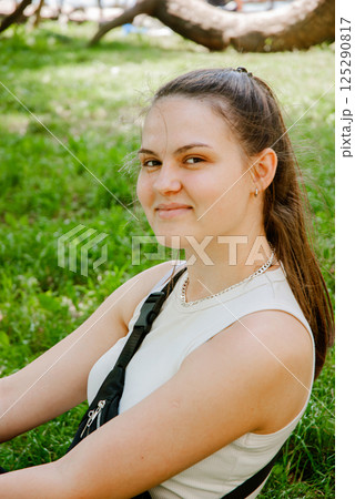 Relaxed outdoor portrait of smiling young woman in casual summer attire. Weekend concept near the forest and lake Relaxed outdoor portrait of smiling young woman in casual summer attire. Weekend concept near the forest and lake 125290817