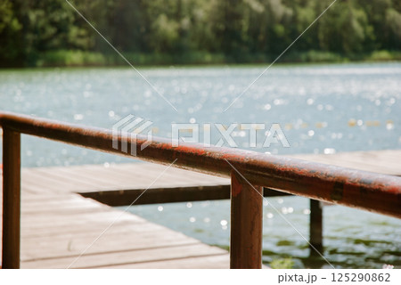 Tranquil lakeside view with wooden dock on a sunny day. Weekend concept near the forest and lake 125290862