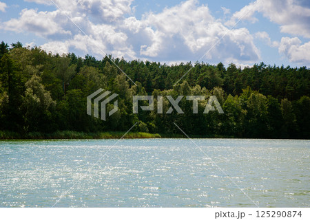 Tranquil summer lake with forest and cloudy sky - nature landscape for relaxation and inspiration. Weekend concept near the forest and lake 125290874