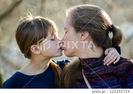 Young mom and her daughter girl together outdoors. 125291714