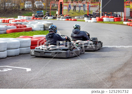 Exciting kart racing competition unfolds on a vibrant outdoor track in springtime Exciting kart racing competition unfolds on a vibrant outdoor track in springtime 125291732