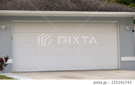 Wide garage double door and concrete driveway of new modern american house 125291743