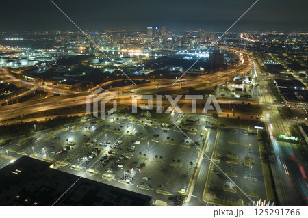 View from above of many parked cars on illuminaded parking lot at night in front of a superstore. Place for vehicles in front of a shopping mall center 125291766