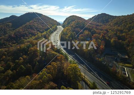 View from above of I-40 freeway route in North Carolina leading to Asheville thru Appalachian mountains with yellow fall woods and fast moving trucks and cars. Interstate transportation concept View from above of I-40 freeway route in North Carolina leading to Asheville thru Appalachian mountains with yellow fall woods and fast moving trucks and cars. Interstate transportation concept 125291769