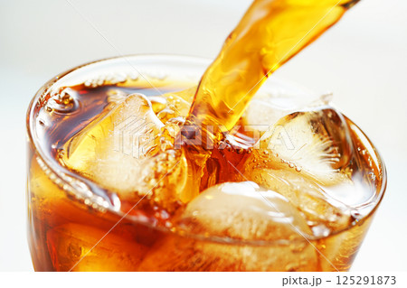 グラスに勢いよく注がれるアイスコーヒー グラスに勢いよく注がれるアイスコーヒー 125291873