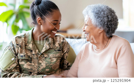 Armed Forces Day female soldier smiling and talking with elderly woman indoors 125291904