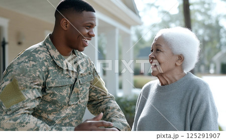 Armed Forces Day smiling african american male soldier in uniform greeting elderly woman outside home 125291907