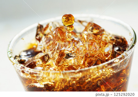 グラスに勢いよく注がれるアイスコーヒー 125292020