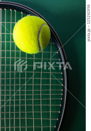 Top view of tennis ball on racket on green background. Concept of sports competitions 125292056