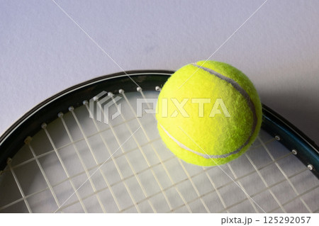 Horizontal picture of a tennis ball on a reaquet. Light background. Copy space 125292057