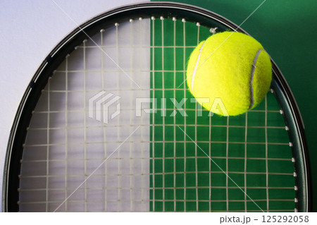 Tennis ball on racket. White and green background. Concept of sports competitions 125292058