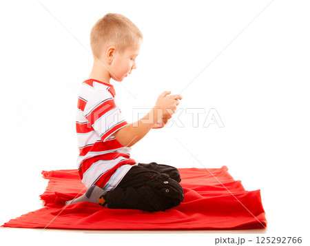 Little boy playing games on smartphone Little boy playing games on smartphone 125292766