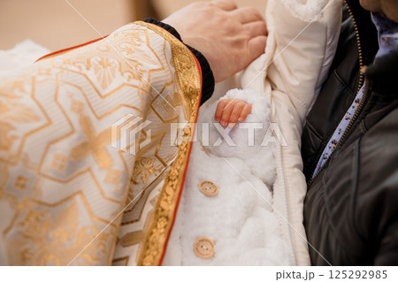 Baptism Ceremony with a Baby in a White Outfit and Ornate Robe 125292985