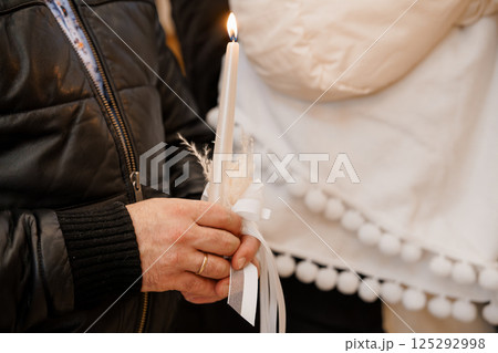 A Person Holding a Candle with a Delicate White Ribbon Decoration A Person Holding a Candle with a Delicate White Ribbon Decoration 125292998