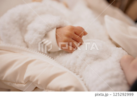 Tender Moment: A Newborn's Hand Grasping a Soft Blanket 125292999