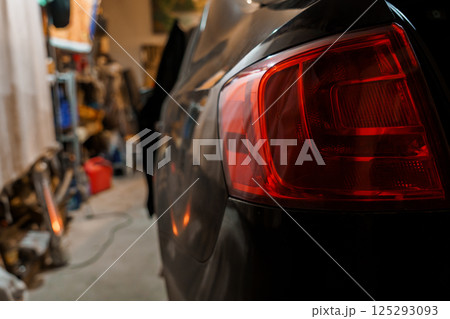 Rear View of a Car Tail Light in a Dimly Lit Garage Setting 125293093