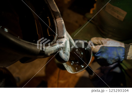 Industrial Worker Pouring Liquid from a Container into a Smaller Vessel Industrial Worker Pouring Liquid from a Container into a Smaller Vessel 125293104