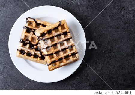 Belgian Waffles with chocolate on black slate background Belgian Waffles with chocolate on black slate background 125293661