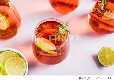 Delicious Negroni cocktail with lime and rosemary in glasses on the table 125294244