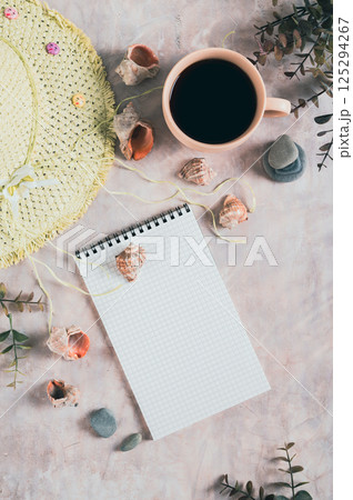 Notebook, beach hat, shells and stones on the table top and vertical view Notebook, beach hat, shells and stones on the table top and vertical view 125294267
