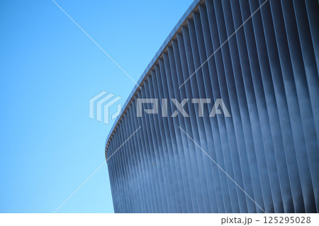 Cladding of a modern sports stadium against a blue sky Cladding of a modern sports stadium against a blue sky 125295028