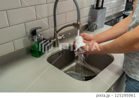 Middle age man washing dishes 125295061
