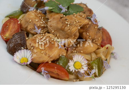 Delicious chicken, linguine, shiitake mushrooms, and garden flowers pasta dish for a delightful Delicious chicken, linguine, shiitake mushrooms, and garden flowers pasta dish for a delightful 125295130