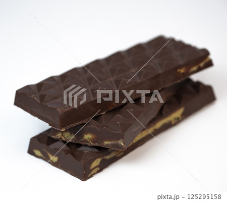 Delicious kadaif layers with rich chocolate and pistachio topping displayed on a clean, white 125295158