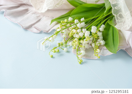 すずらんの花とピンクのクロス|ブルー背景 すずらんの花とピンクのクロス|ブルー背景 125295181