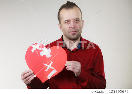 Sad adult man holding broken heart Sad adult man holding broken heart 125295672