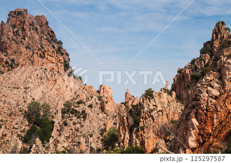 A picturesque view of rocky mountain formations under blue sky. Corsica 125297587