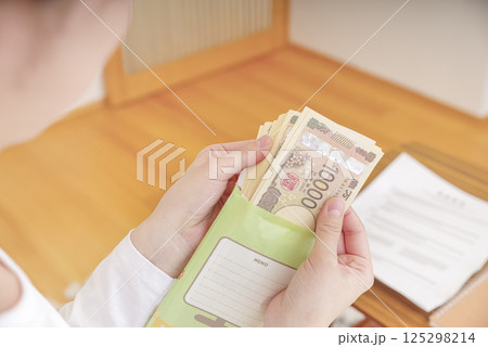 封筒に入ったお金を持つ女性 封筒に入ったお金を持つ女性 125298214