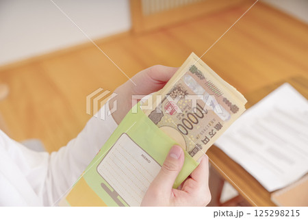 封筒に入ったお金を持つ女性 封筒に入ったお金を持つ女性 125298215