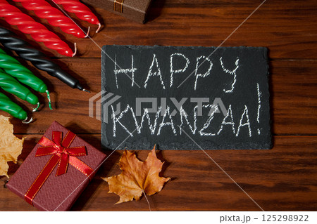 Kwanzaa African American holiday. Seven candles red, black and green on natural wooden background. 125298922