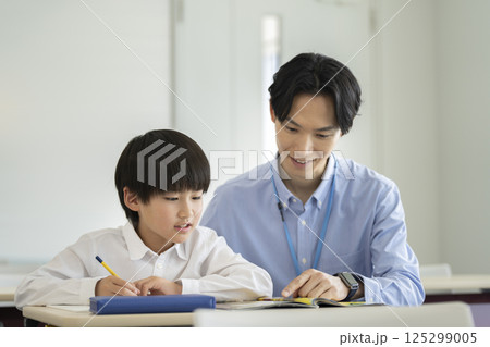 勉強する小学4年生の男の子と先生 勉強する小学4年生の男の子と先生 125299005