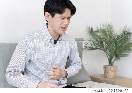お腹が痛い男性　腹痛　胃腸炎　下痢　便秘 125300129