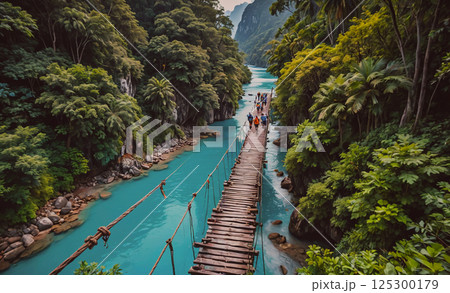 Group of people are walking across a wooden bridge over a river. The bridge is surrounded by lush green trees and the water is a beautiful shade of blue. The scene is peaceful and serene Group of people are walking across a wooden bridge over a river. The bridge is surrounded by lush green trees and the water is a beautiful shade of blue. The scene is peaceful and serene 125300179