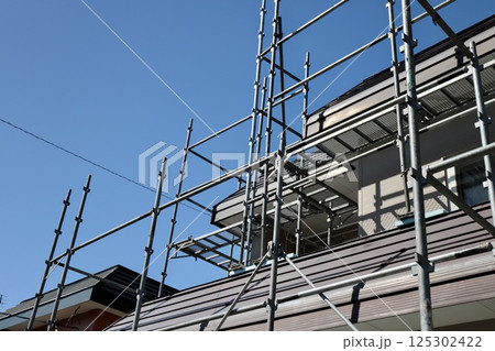 くさび足場をかけた古い一戸建の工事現場 くさび足場をかけた古い一戸建の工事現場 125302422