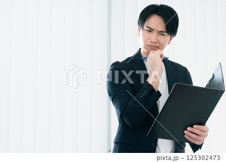 資料を精査するカジュアルスタイルのビジネスマン 125302473