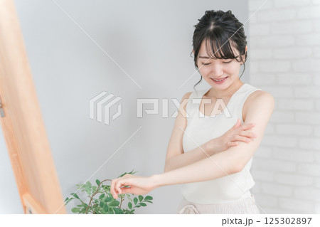 ボディケア・脱毛・保湿・日焼け止めを塗るアジア人女性 ボディケア・脱毛・保湿・日焼け止めを塗るアジア人女性 125302897