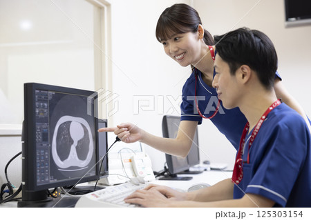 モニターでCTスキャンの検査結果を見る放射線技師　撮影協力：学校法人電波学園　東京電子専門学校 125303154