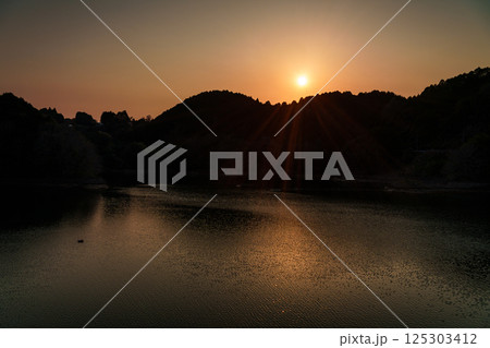 対岸の山並みに沈んで行く夕日 インターバル撮影連続写真 奈良布目ダムにて③ 対岸の山並みに沈んで行く夕日 インターバル撮影連続写真 奈良布目ダムにて③ 125303412