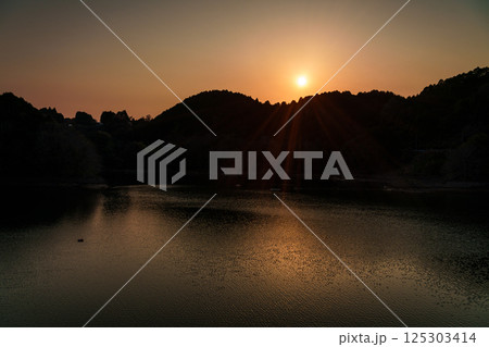 対岸の山並みに沈んで行く夕日　インターバル撮影連続写真　奈良布目ダムにて⑤ 125303414