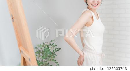 鏡でお尻をチェックして笑顔のアジア人女性（ヒップアップ） 125303748